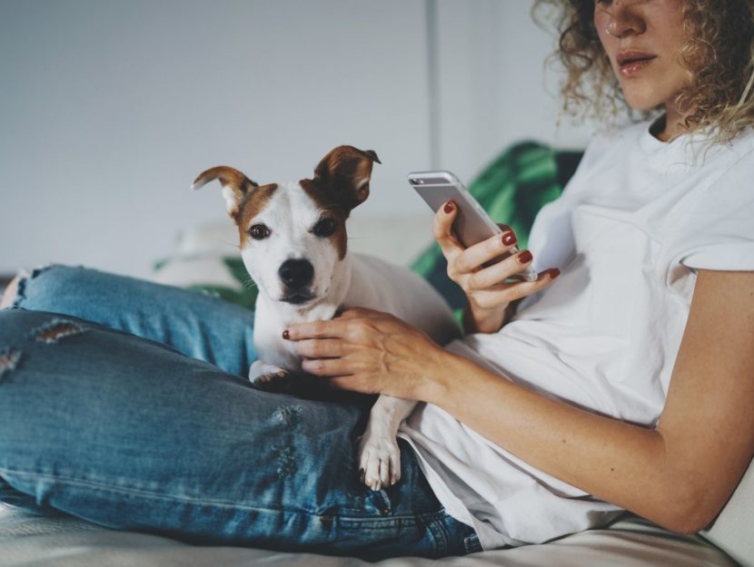 Donna con smartphone e cane