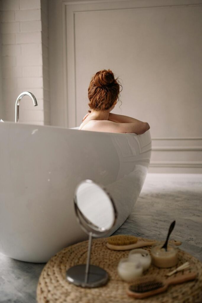 Donna di schiena con capelli raccolti in vasca da bagno 