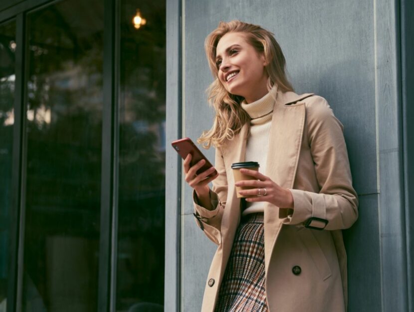 Donna beve caffè e sta al cellulare