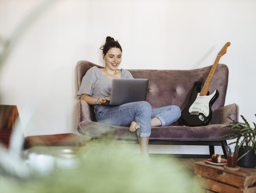 Ragazza divano computer chitarra