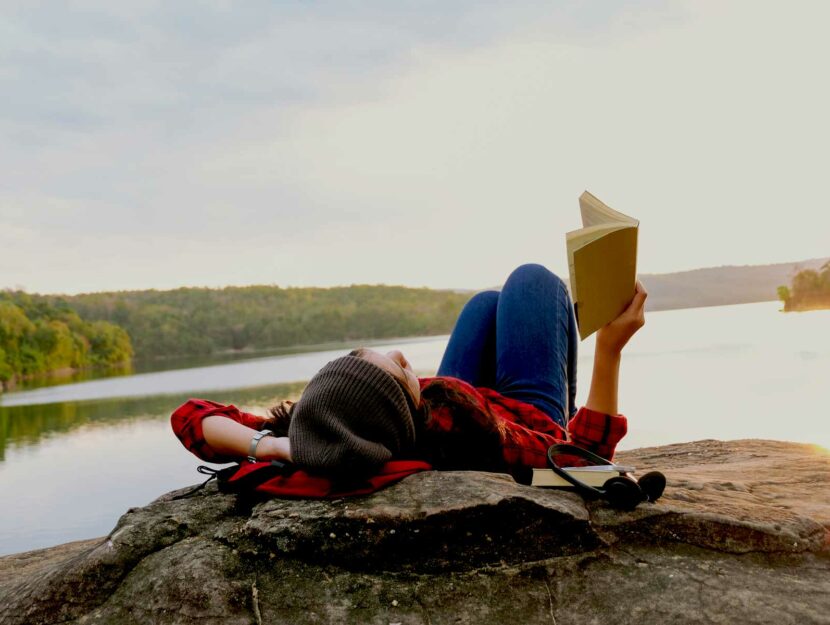 Ragazza legge libro lago