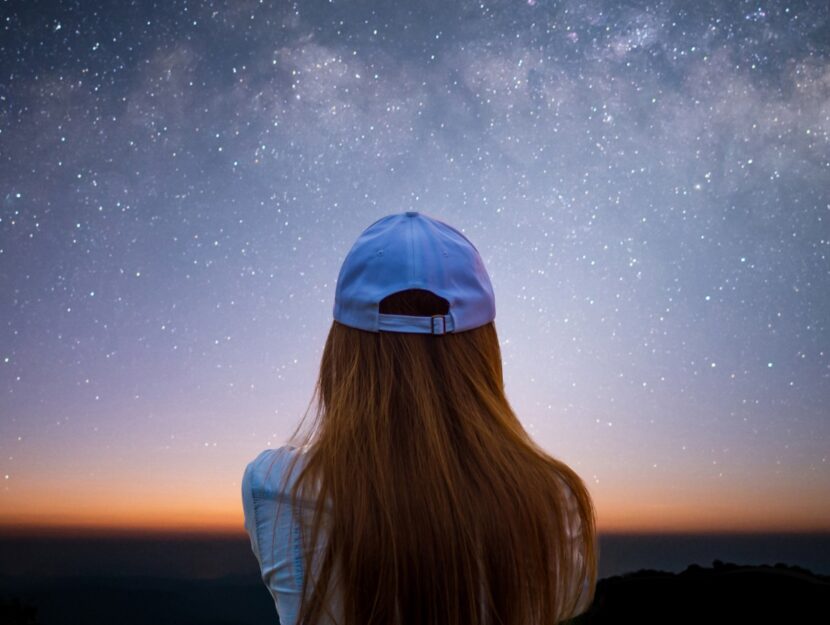 ragazza con berretto che guarda il cielo