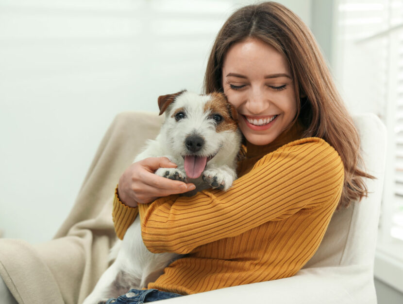 Donna felice con cane a casa