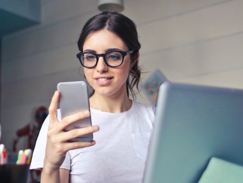 ragazza in ufficio che guarda lo smartphone