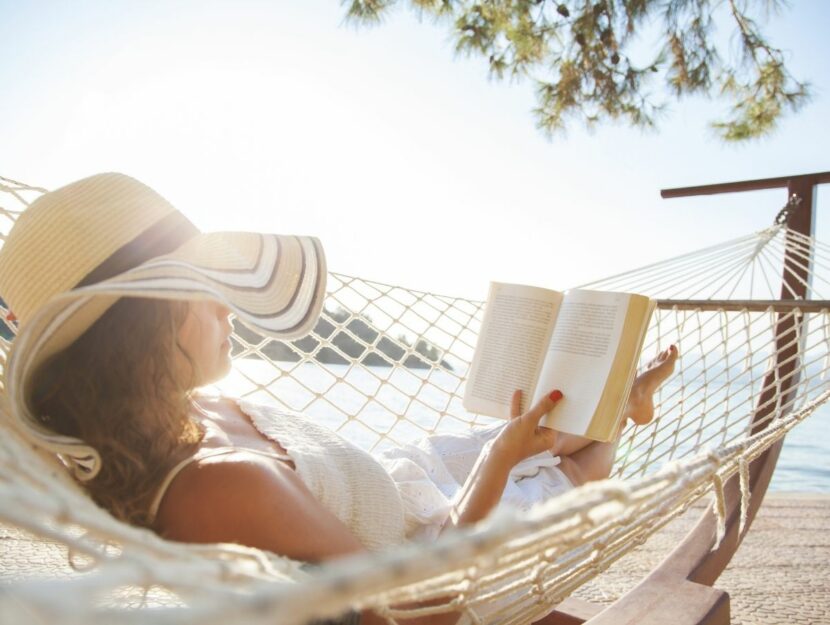 Donna legge un libro al mare