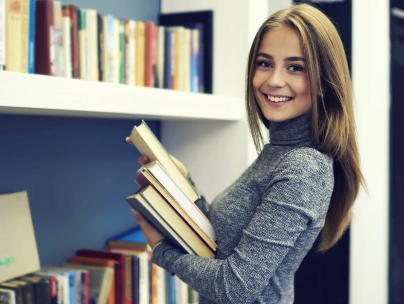 donna sorride con libri