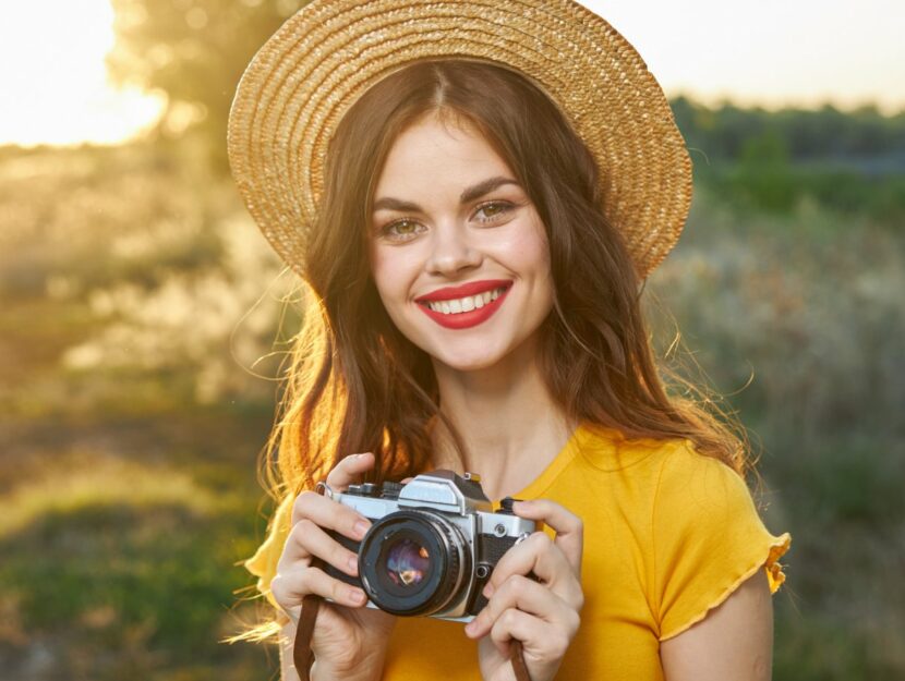 ragazza con cappello di paglia e macchina fotografica