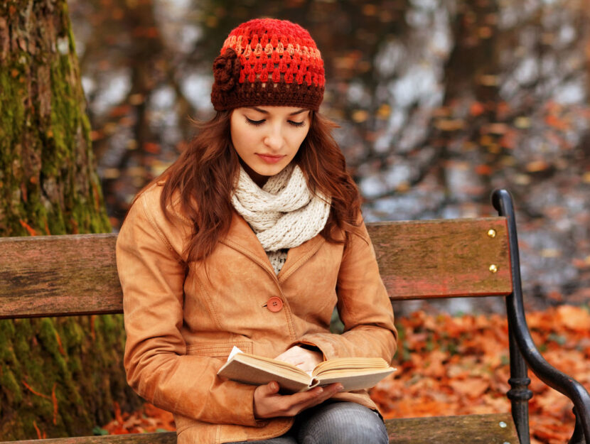 Ragazza capello libro panchina nel bosco autunno