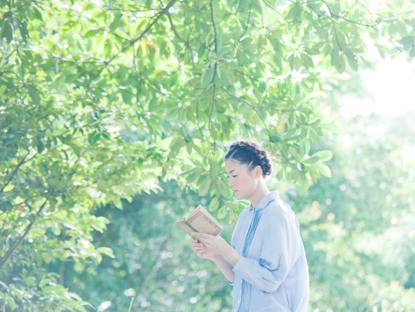 Ragazza giapponese legge libro alberi