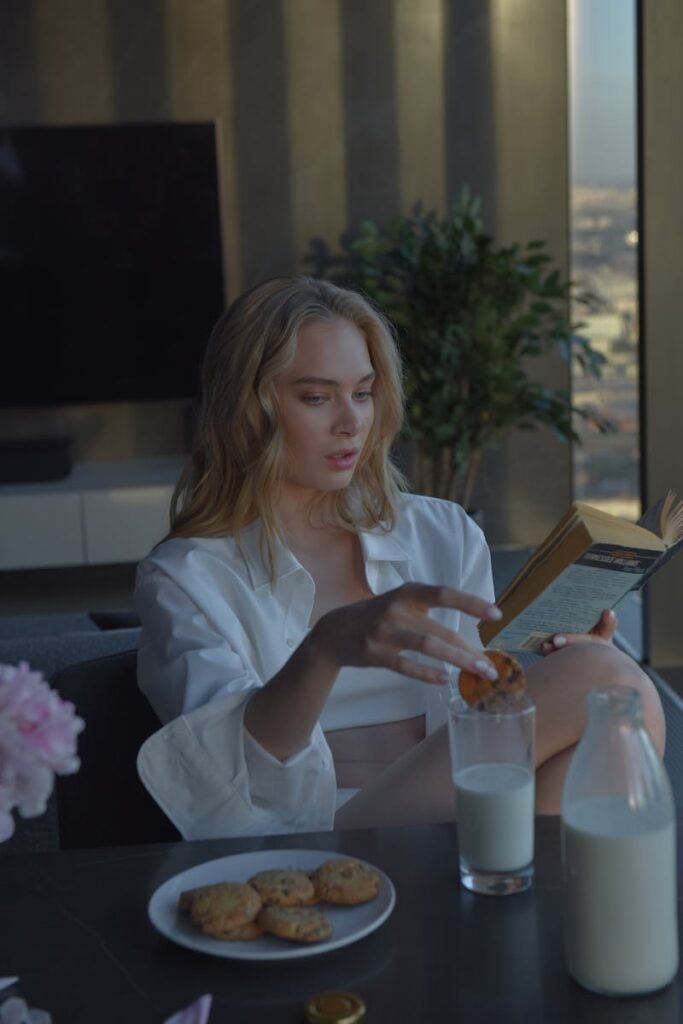 ragazza sta mangiando biscotti inzuppati nel latte