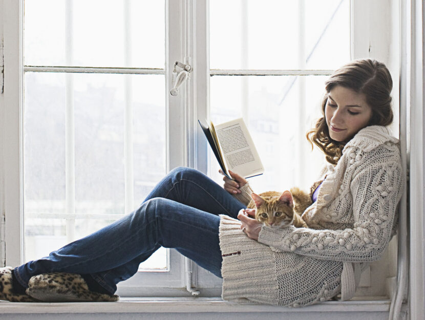 donna legge libro gatto