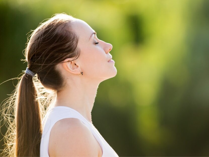 donna che respira in giardino, donna che pratica tecniche di respirazione