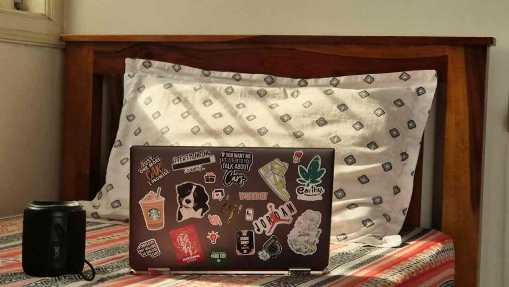 computer con adesivi poggiato sul letto in cameretta