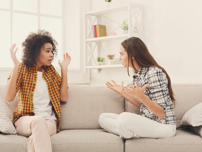 Due amiche litigano su un divano bianco