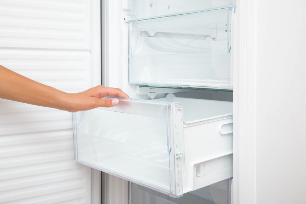 mano di donna che aprono cassetto del freezer