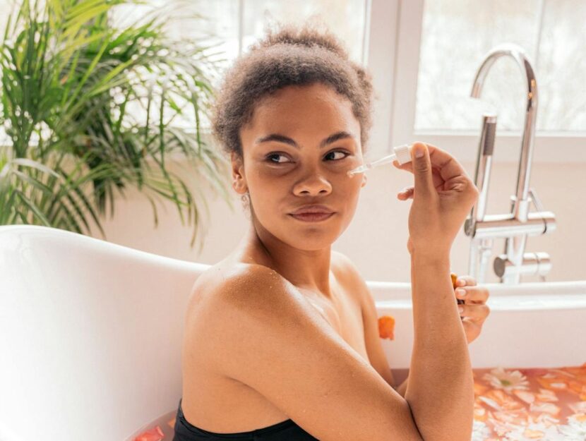 ragazza che si sta mettendo un siero al viso durante una beauty routine