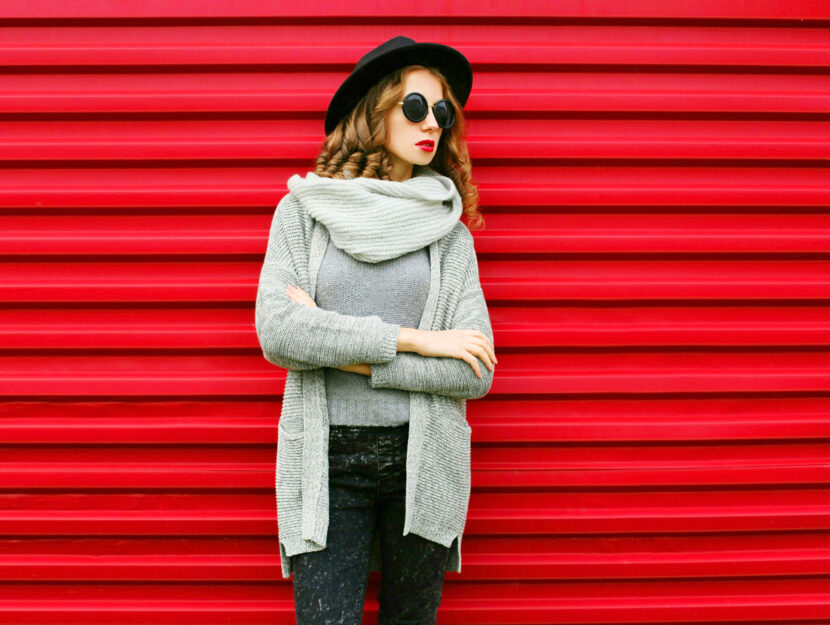 Donna moda cardigan grigio sfondo rosso