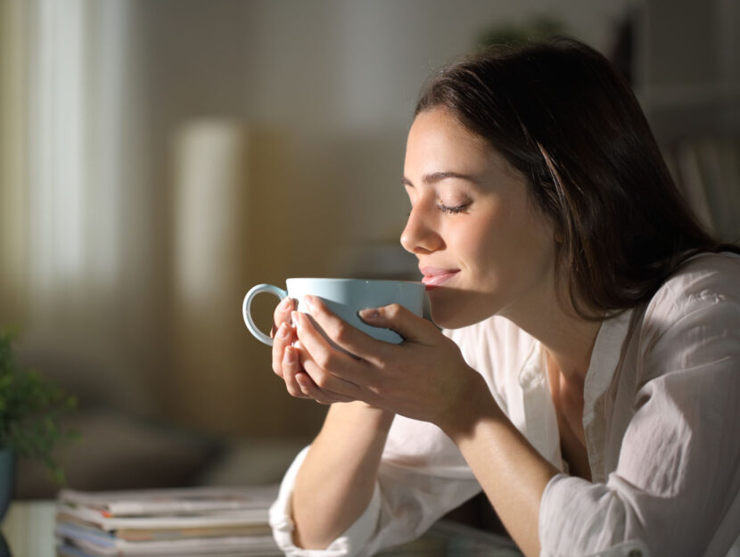 Donna beve caffè in casa