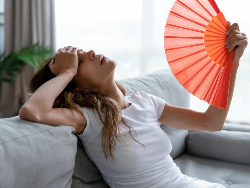 Donna caldo ventaglio sul divano