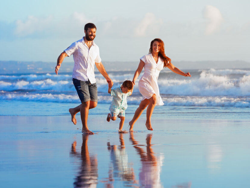 Famiglia corre sulla spiaggia vacanza mare