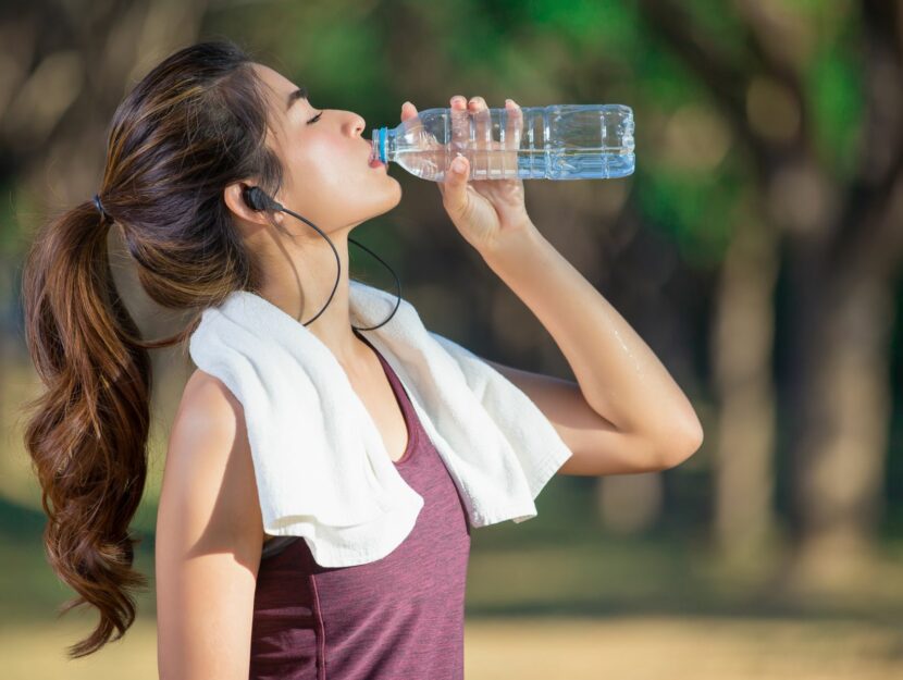 Donna beve per bilanciare allenamento e idratazione