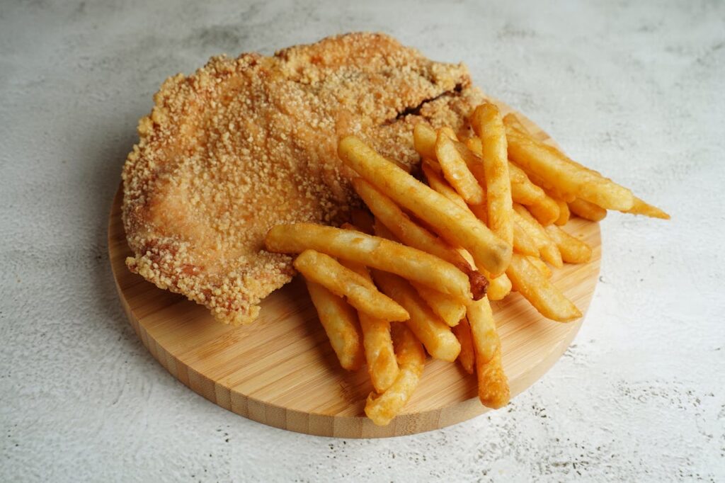 tagliere con cotoletta e patatine fritte