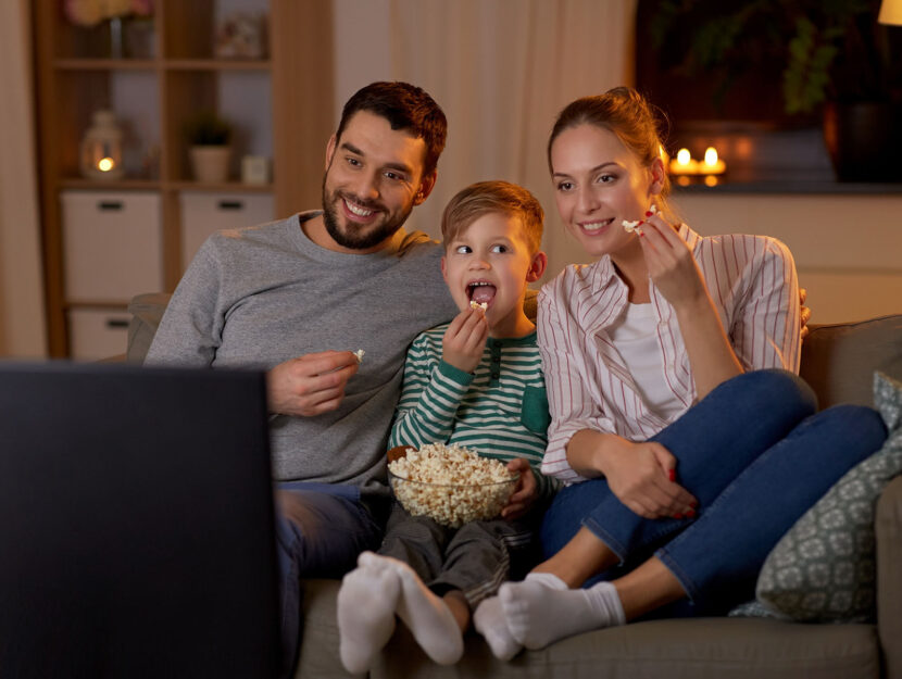 Genitori bambino popcorn tv televisione divano