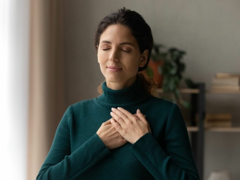 Ragazza con le mani sul cuore e maglione verde