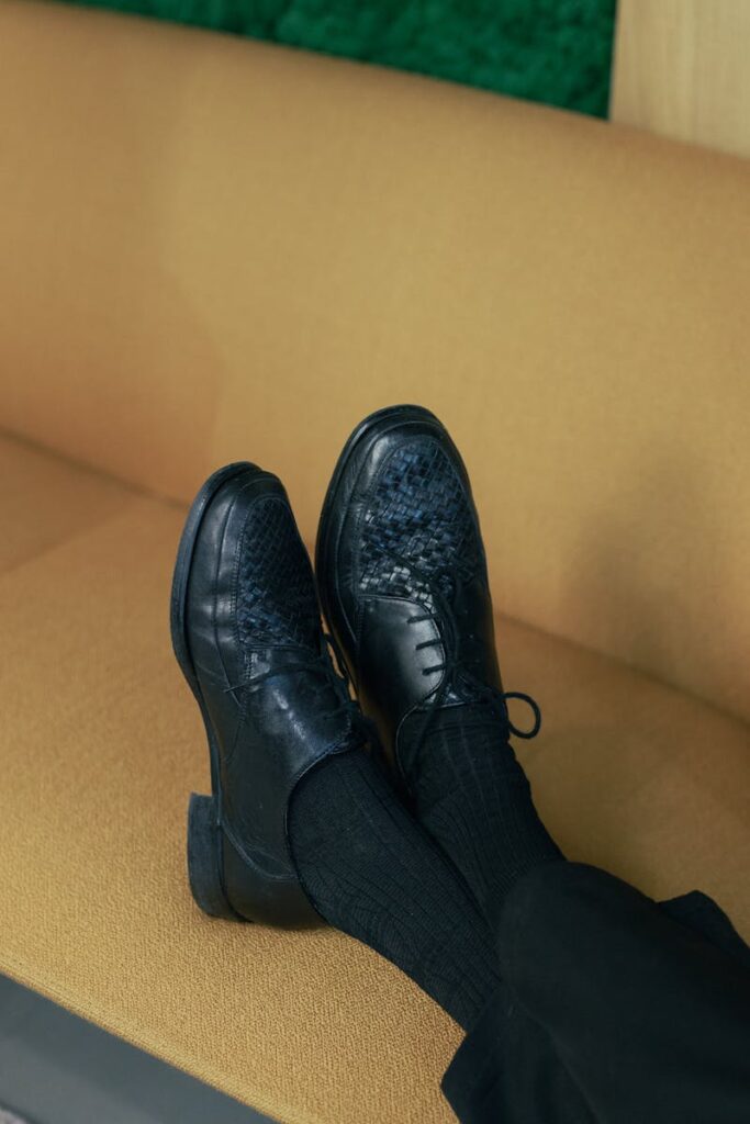 uomo seduto con le scarpe sul divano