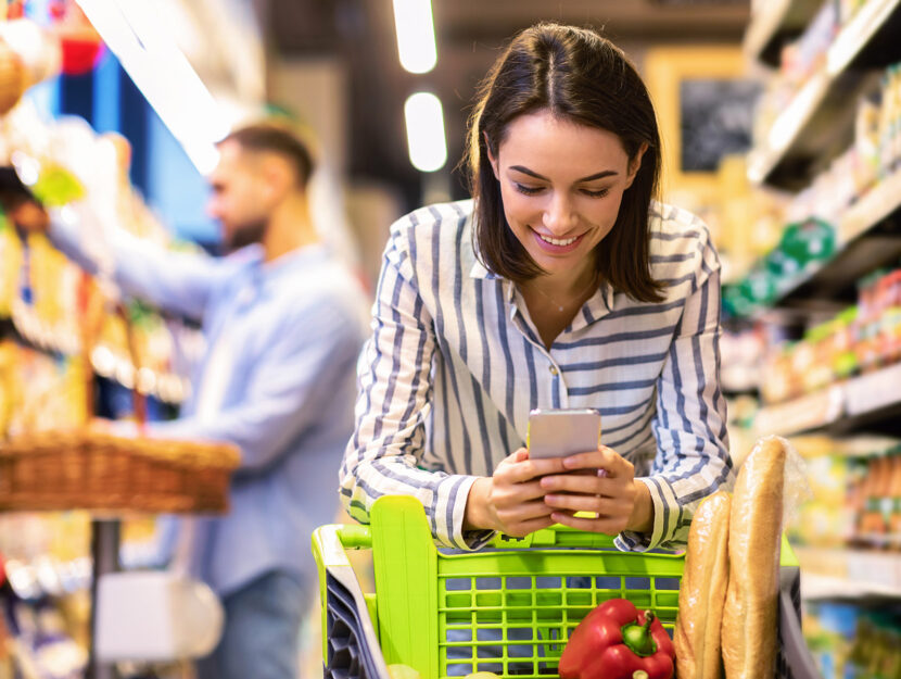 Donna cellulare carrello spesa supermercato