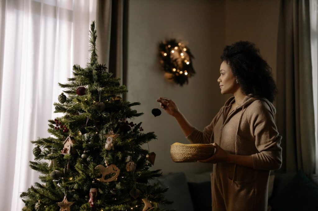 ragazza sta appendendo le decorazioni all'albero