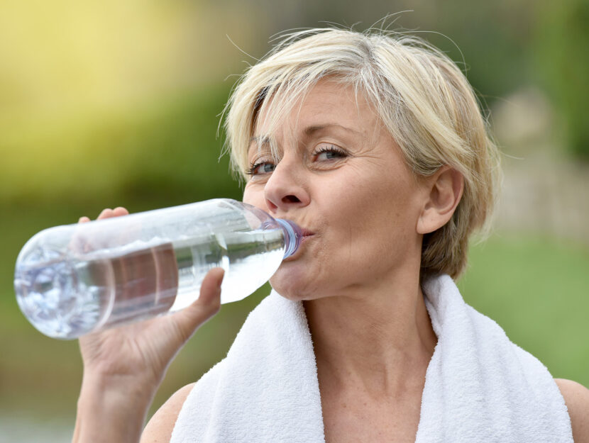 Donna 60 anni bere acqua allenamento