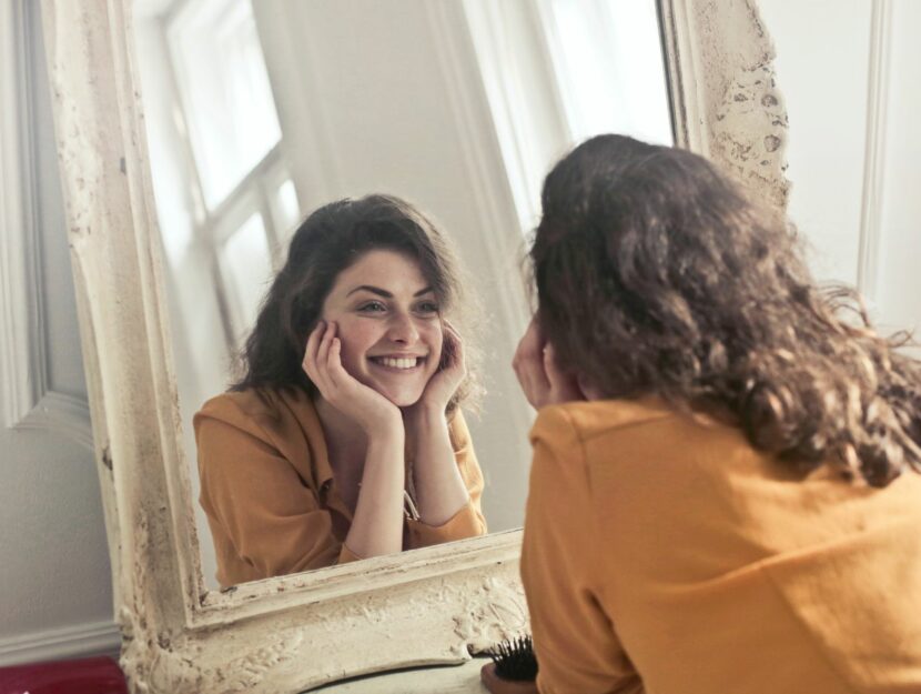 Donna si guarda allo specchio sorridendo