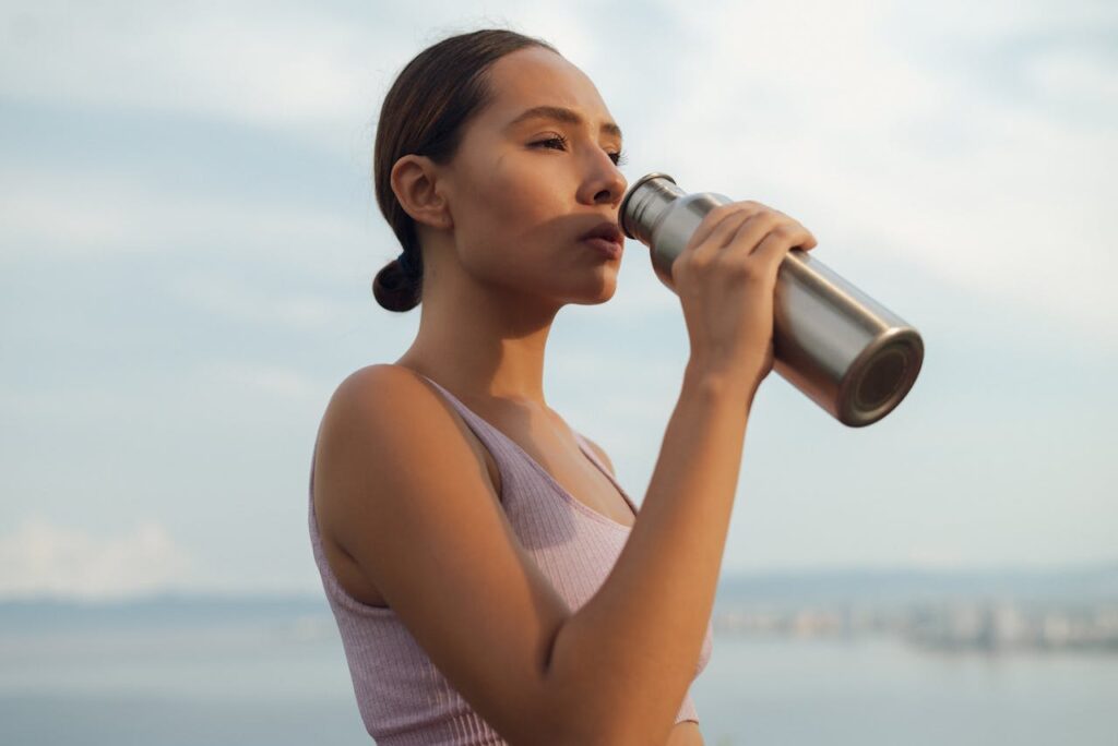 ragazza beve acqua dalla borraccia