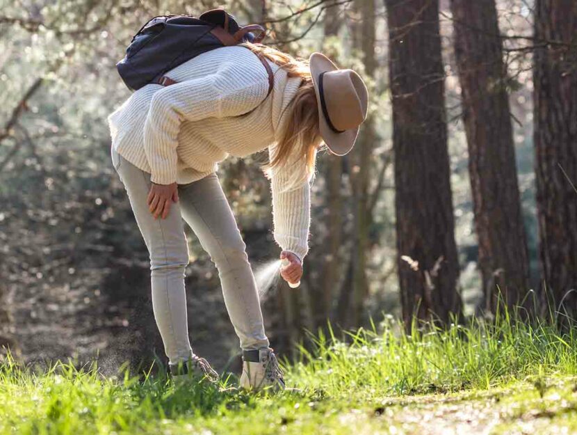 Una ragazza spruzza un repellente contro le zecche