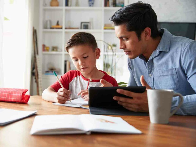 Un padre aiuta il figlio a fare i compiti a casa