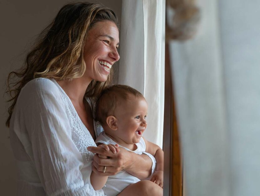 Mamma sorridente con figlio in braccio