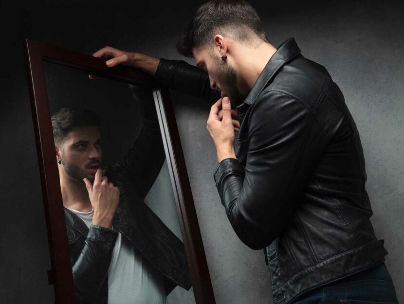 Un uomo narcisista si guarda allo specchio