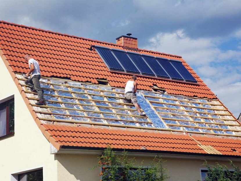Due operai installano i pannelli solari su un tetto