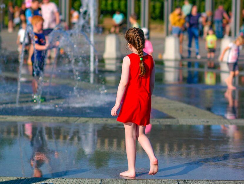 Bambina a piedi nudi e giochi d'acqua