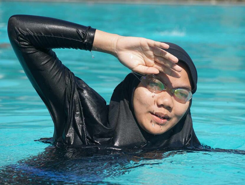 Donna musulmana nuota in piscina