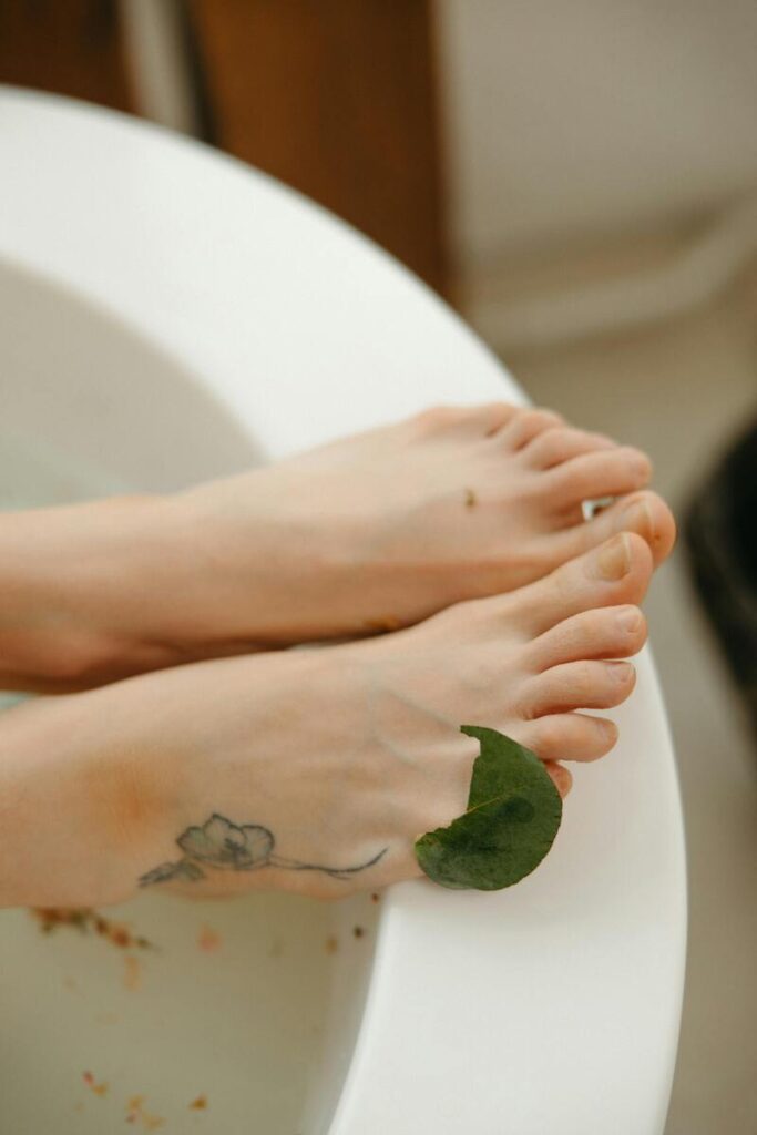 Piedi in bordo vasca da bagno con foglia