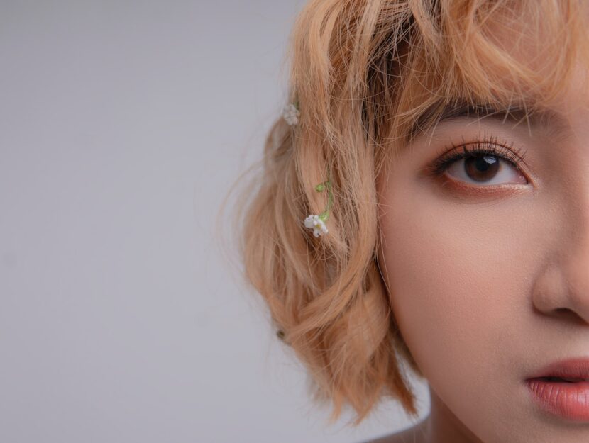 ragazza in primo piano truccata con fiori nei capelli