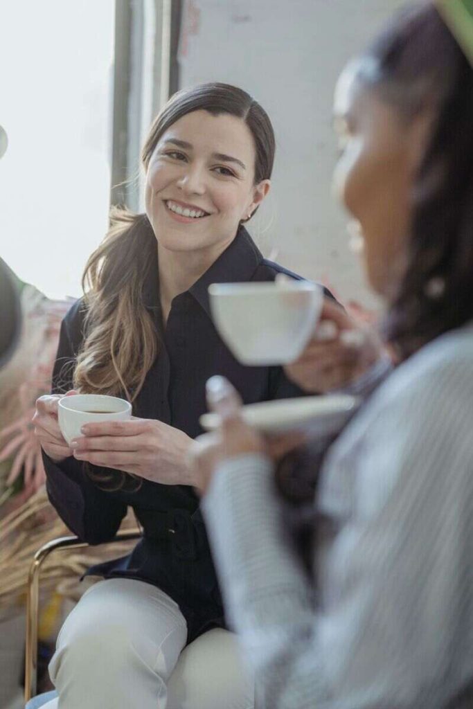 donna che sorride con tazza di caffe in mano