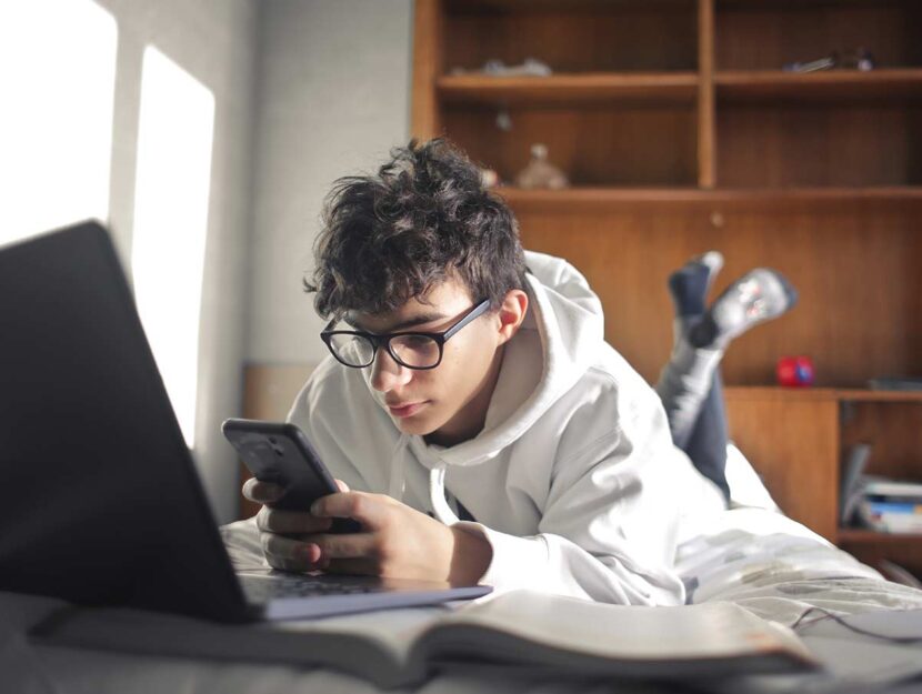 Giovane davanti a smartphone e pc