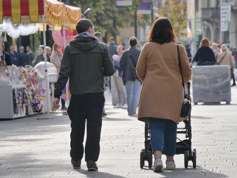 Coppia cammina in strada con passeggino