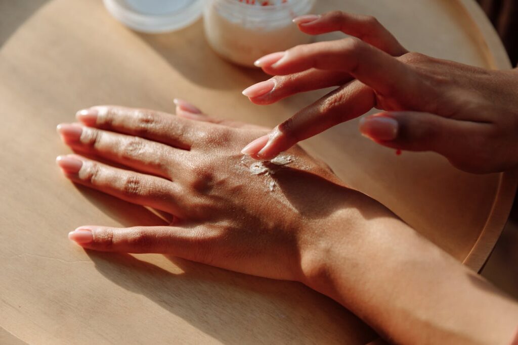 ragazza si sta spalmando la crema sulle mani