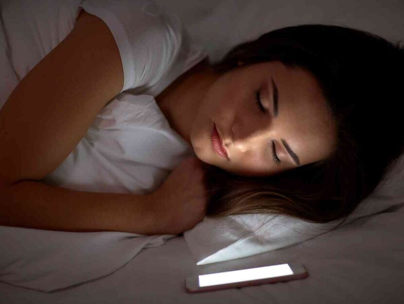 Una donna dorme con il cellulare