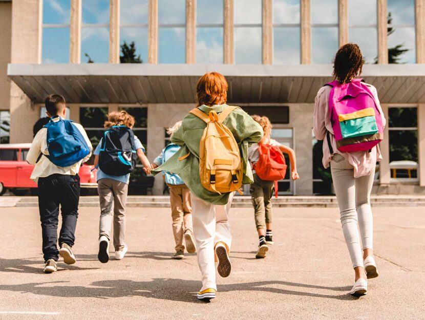 Studenti di spalle entrano a scuola