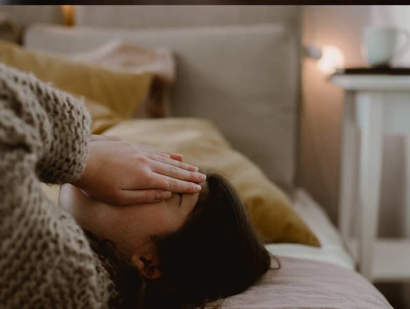 Giovane distesa sul letto si copre il viso con l emani